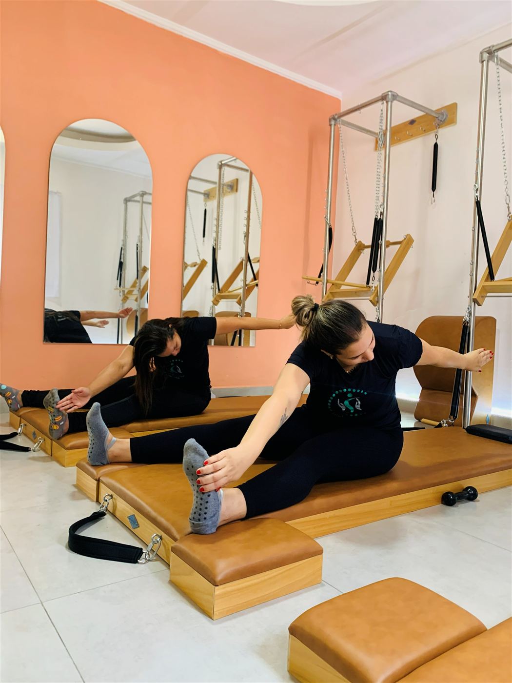 Alunas fazendo alongamento em aula de Pilates clássico