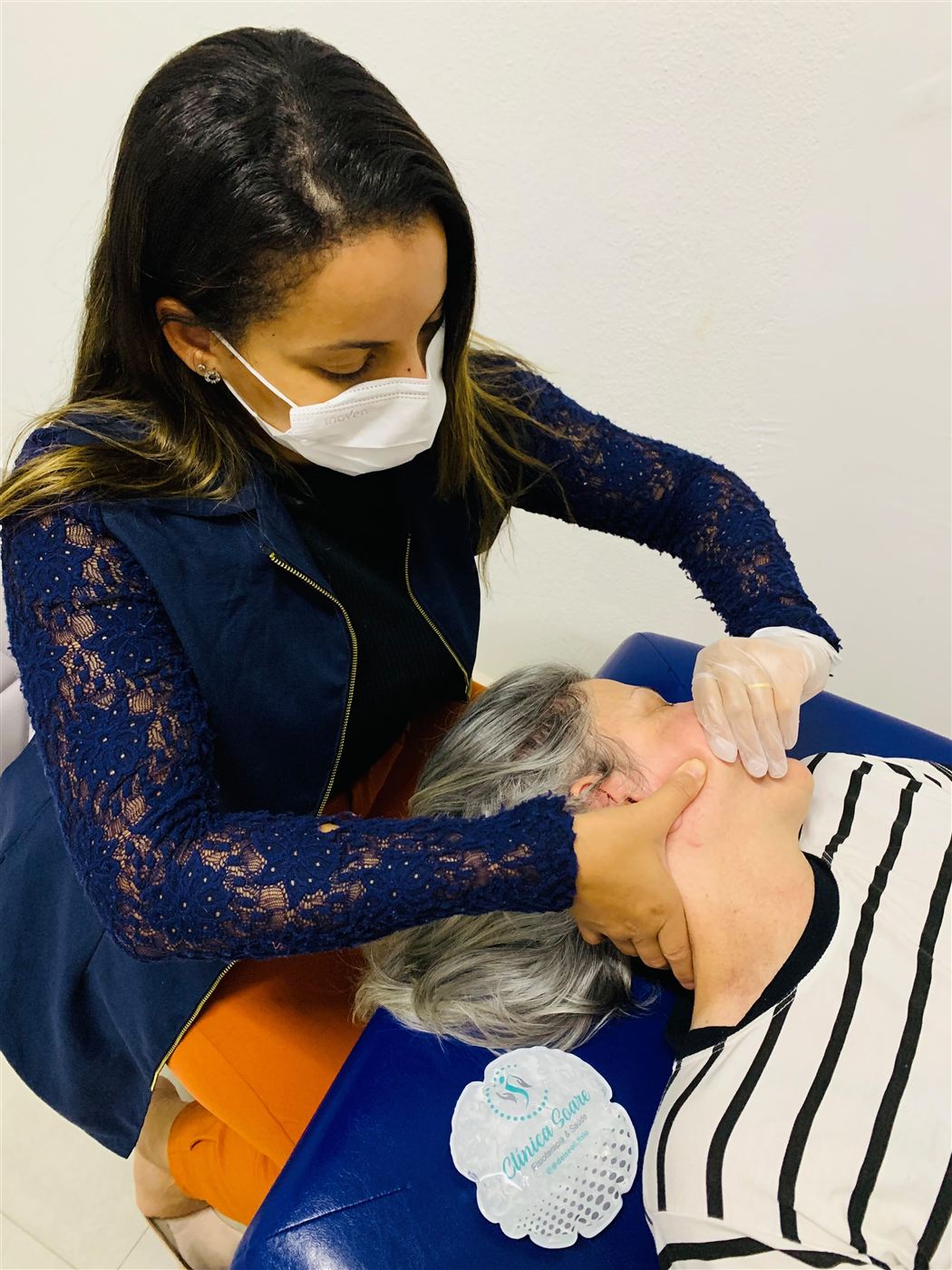 Fisioterapeuta Deise O. Soares realizando terapia manual na mandíbula e no pescoço de paciente