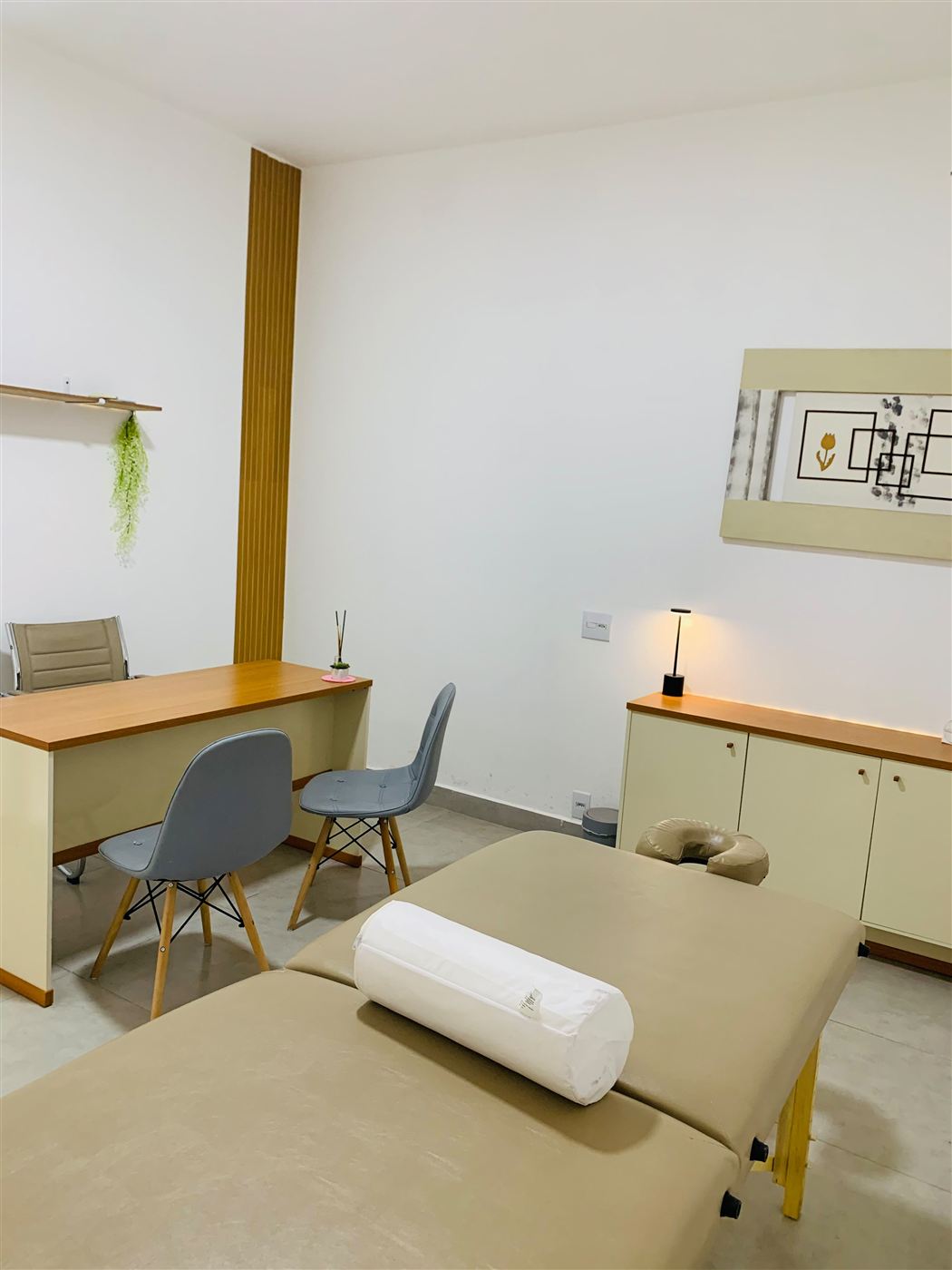 Sala de massagem e coworking com maca e mesa de atendimento